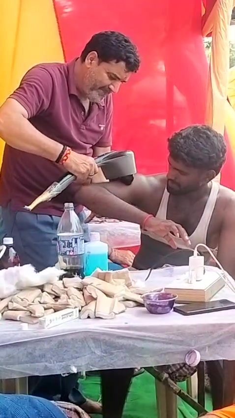 Doctor bandaging a pilgrim's arm at the camp