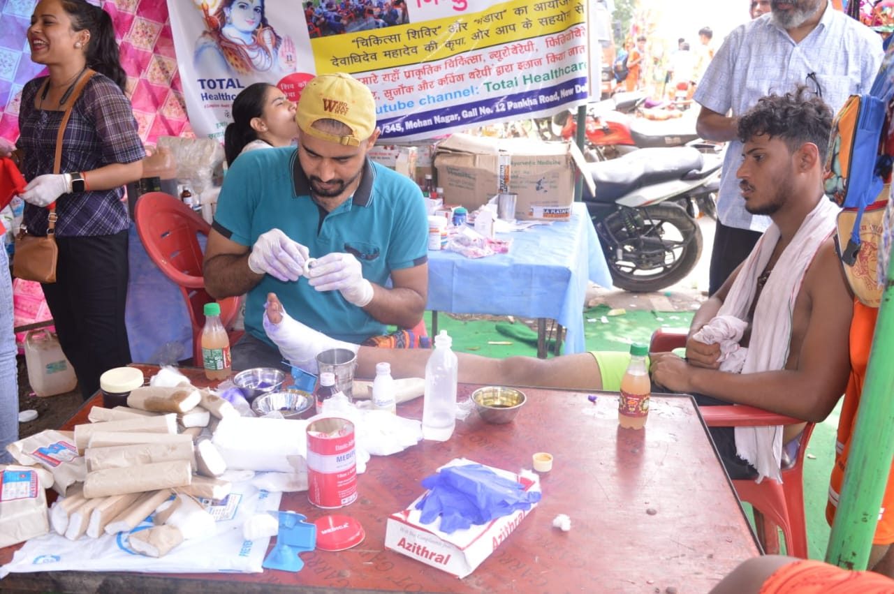 Doctor treating a pilgrim's foot at medical camp